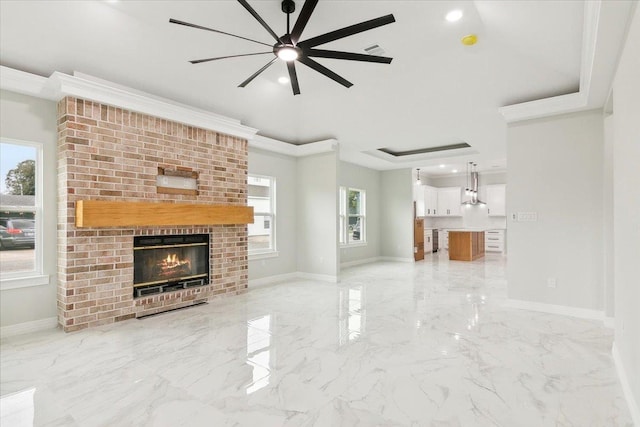 unfurnished living room featuring ceiling fan, a fireplace, and crown molding