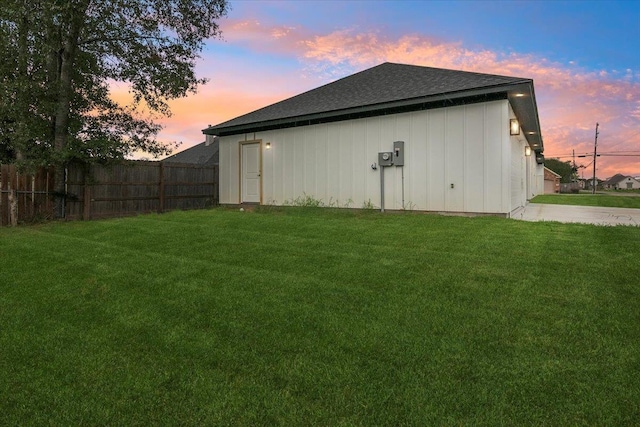 property exterior at dusk with a lawn