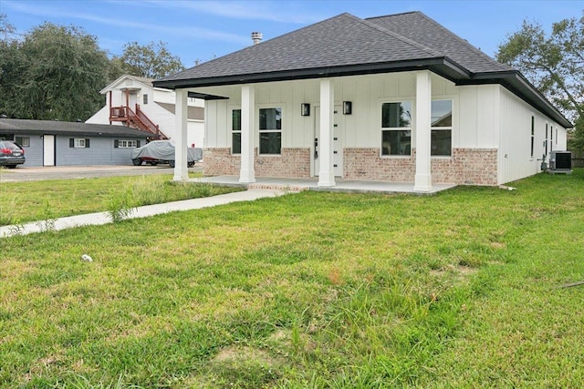 back of house with a lawn, covered porch, and central AC unit