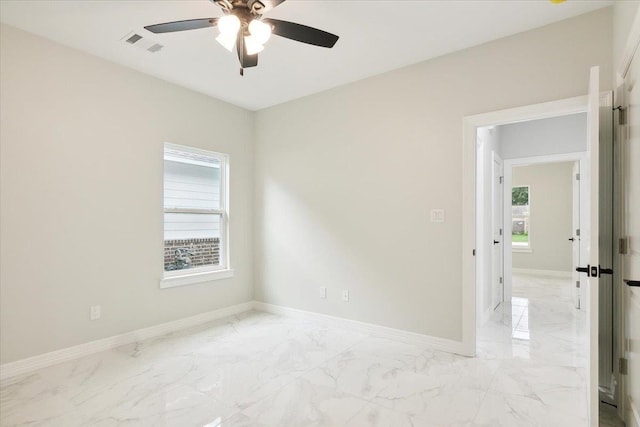 spare room featuring plenty of natural light and ceiling fan