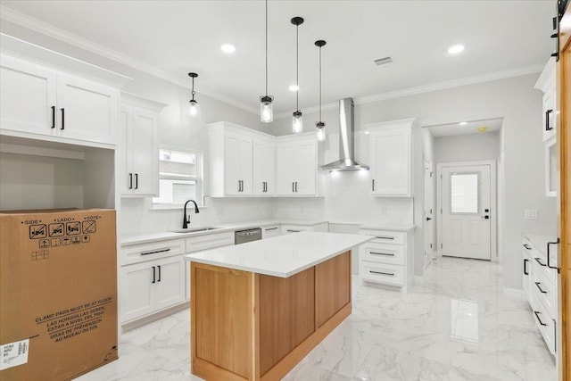 kitchen with white cabinets, a kitchen island, wall chimney exhaust hood, and sink