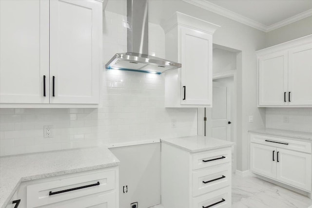 kitchen featuring light stone countertops, wall chimney exhaust hood, decorative backsplash, white cabinets, and ornamental molding