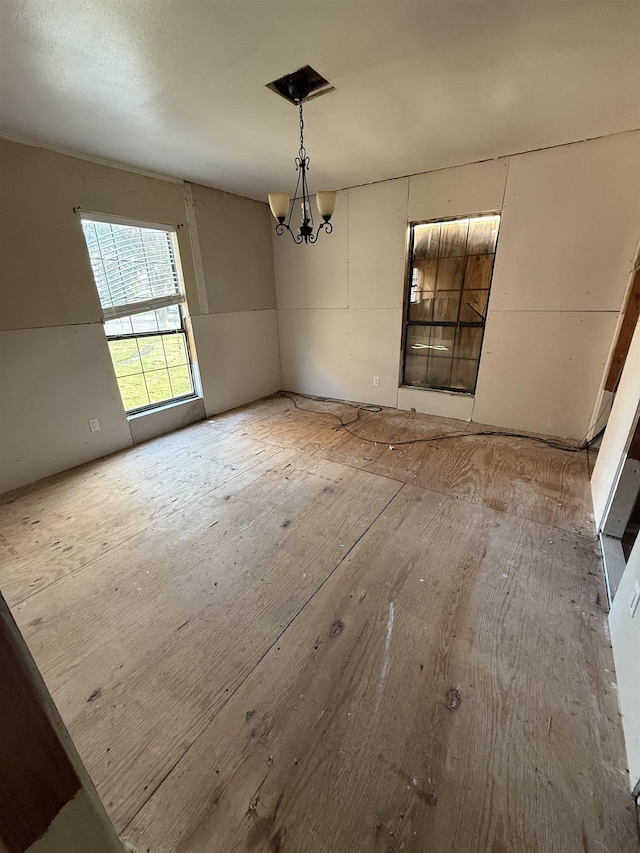 unfurnished dining area featuring a chandelier