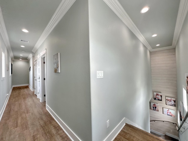 hallway with ornamental molding, recessed lighting, baseboards, and wood finished floors