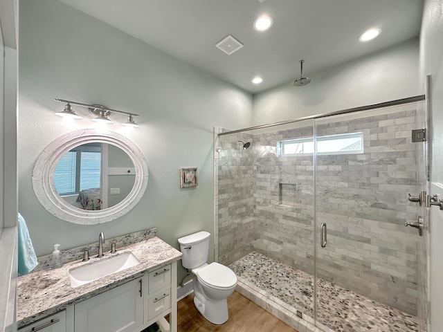 full bath featuring visible vents, toilet, wood finished floors, vanity, and a shower stall