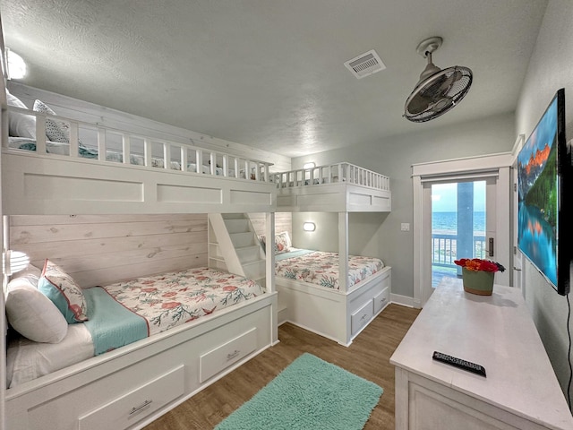 bedroom with access to exterior, visible vents, and dark wood-style flooring