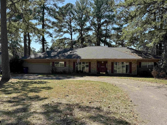 single story home with driveway, a front lawn, and brick siding