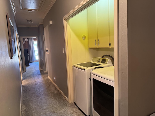 clothes washing area with carpet floors, cabinet space, ornamental molding, washing machine and dryer, and attic access