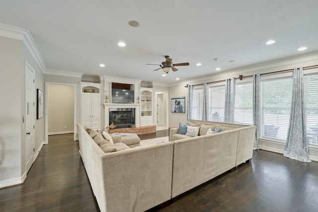 2250 Savannah Trce, Beaumont, TX 77706 - living area with crown molding, a ceiling fan, a glass covered fireplace, dark wood-style flooring, and recessed lighting