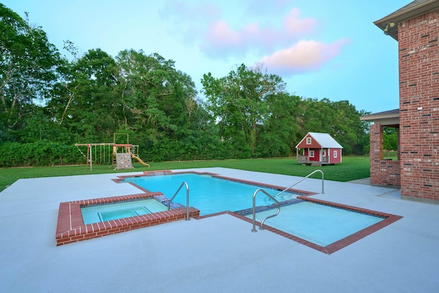 2250 Savannah Trce, Beaumont, TX 77706 - outdoor pool with a patio, an in-ground hot tub, a yard, an outbuilding, and a playground