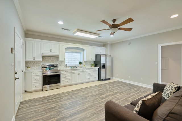 2250 Savannah Trce, Beaumont, TX 77706 - kitchen with stainless steel appliances, ceiling fan, under cabinet range hood, light countertops, and ornamental molding
