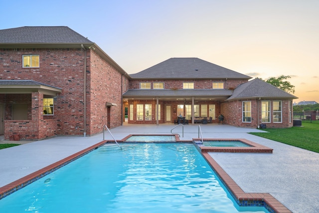 2250 Savannah Trce, Beaumont, TX 77706 - pool at dusk featuring a patio and a pool with connected hot tub