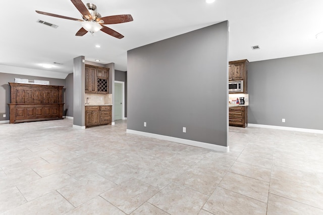 unfurnished living room with ceiling fan