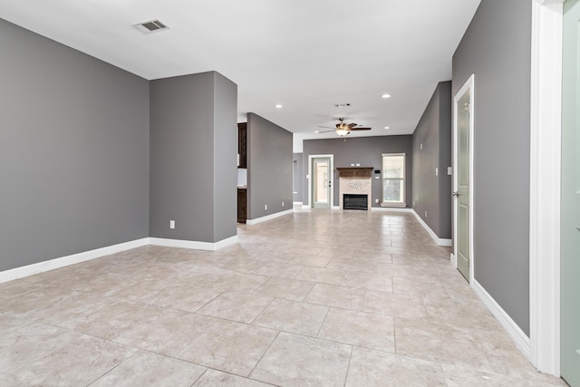 unfurnished living room with ceiling fan and light tile patterned floors