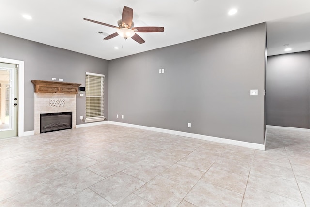 unfurnished living room featuring a tile fireplace and ceiling fan