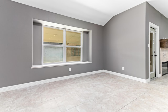 unfurnished room with lofted ceiling