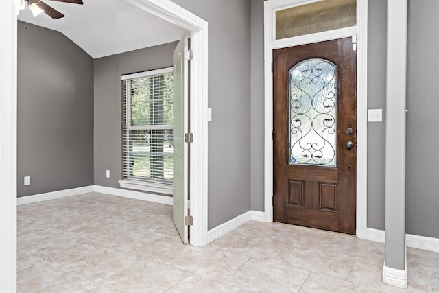 foyer entrance featuring ceiling fan, a healthy amount of sunlight, and lofted ceiling