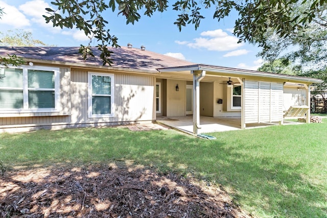 rear view of house with a patio, ceiling fan, and a lawn