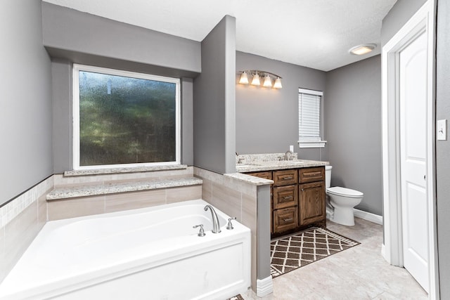 bathroom with a textured ceiling, vanity, toilet, and a bathing tub