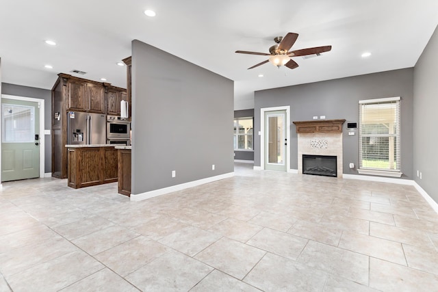 unfurnished living room with ceiling fan and light tile patterned flooring