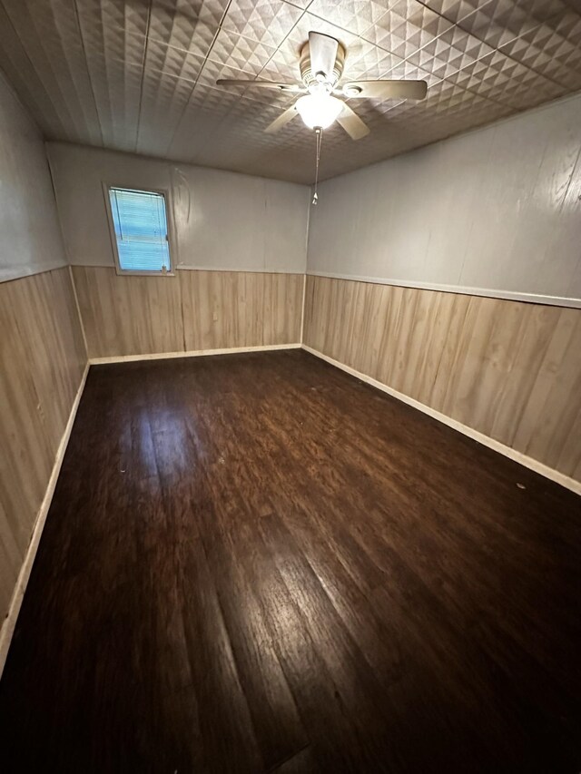 1901 14th St, Port Arthur, TX 77640 - unfurnished room with dark wood-style flooring, a wainscoted wall, a ceiling fan, and wood walls
