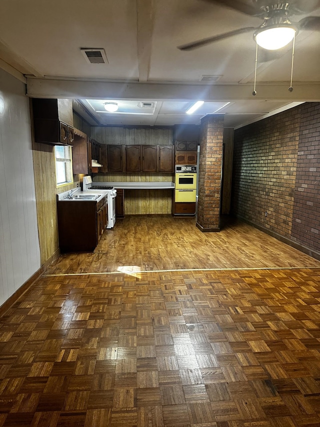 1901 14th St, Port Arthur, TX 77640 - kitchen featuring white appliances, brick wall, dark brown cabinets, light countertops, and baseboards