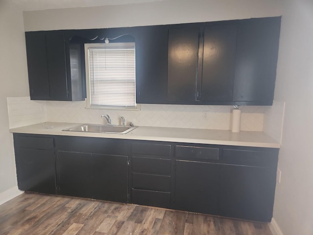 1313 Block St, Port Neches, TX 77651 - kitchen featuring dark cabinets, a sink, and decorative backsplash