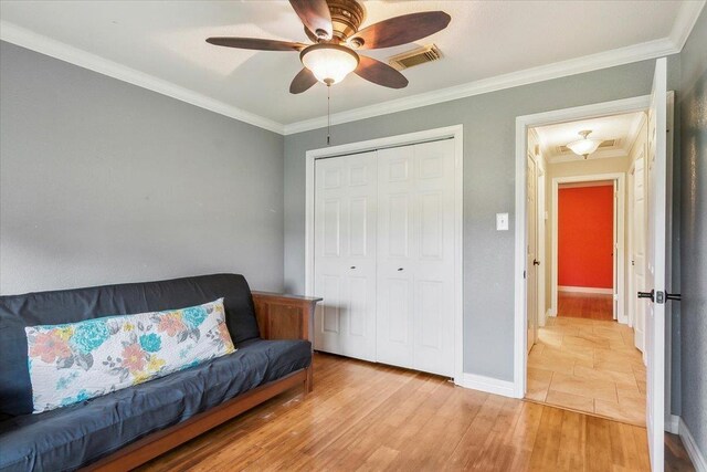 living area with ceiling fan, light wood-type flooring, and ornamental molding