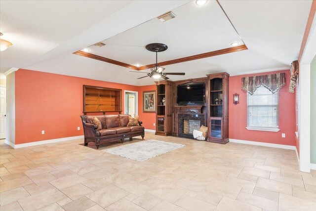 living room with a tray ceiling, ceiling fan, and ornamental molding