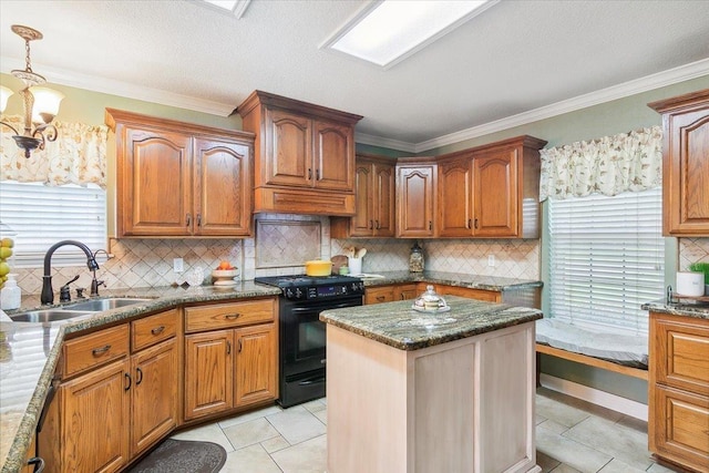 kitchen featuring dark stone counters, black range with electric cooktop, sink, light tile patterned floors, and decorative light fixtures