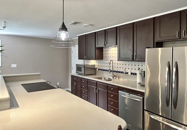 kitchen with dark brown cabinetry, sink, stainless steel appliances, backsplash, and pendant lighting