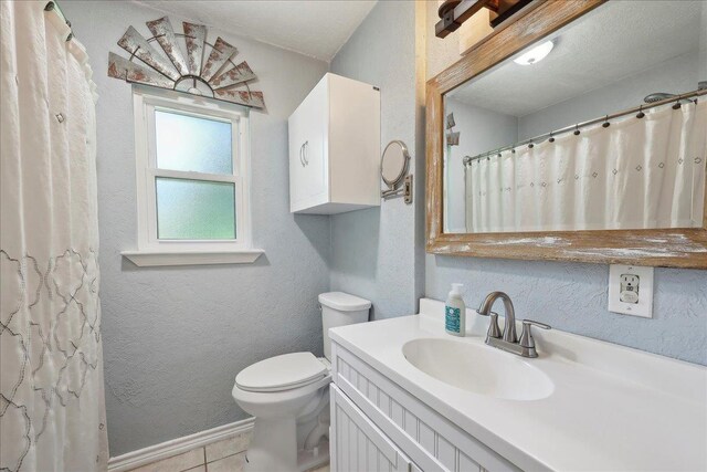 233 Spooner St, Orange, TX 77630 - full bath featuring toilet, a textured wall, vanity, tile patterned floors, and a shower with shower curtain