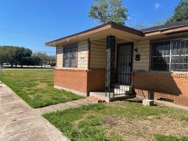 view of exterior entry with a lawn