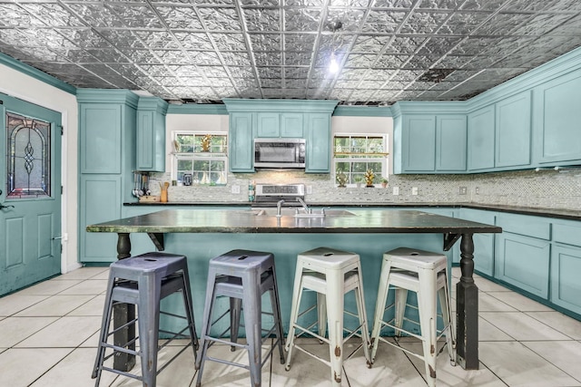 7775 River Rd, Beaumont, TX 77713 - kitchen featuring stainless steel appliances, dark countertops, healthy amount of natural light, and an ornate ceiling