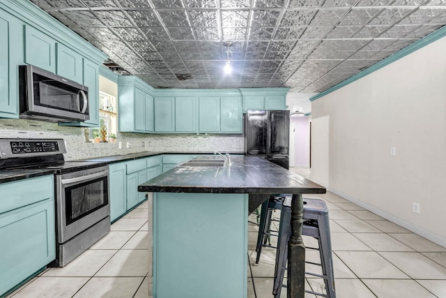 7775 River Rd, Beaumont, TX 77713 - kitchen featuring appliances with stainless steel finishes, dark countertops, blue cabinetry, a breakfast bar area, and an ornate ceiling