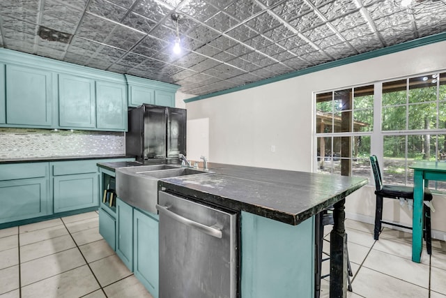 7775 River Rd, Beaumont, TX 77713 - kitchen featuring stainless steel dishwasher, an ornate ceiling, dark countertops, a center island with sink, and light tile patterned floors
