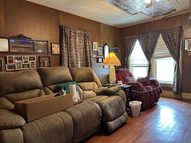 interior space with crown molding, ceiling fan, wood-type flooring, and wood walls