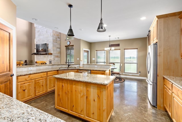 kitchen with a center island, stainless steel fridge, light stone countertops, and kitchen peninsula