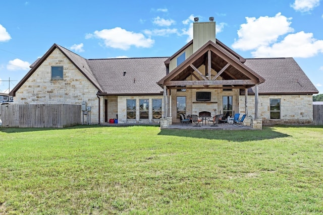 rear view of property with a lawn, a fireplace, and a patio