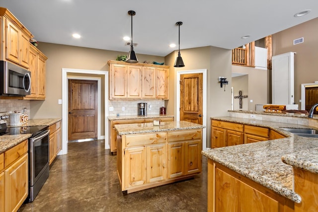 kitchen with a center island, light stone countertops, sink, and appliances with stainless steel finishes