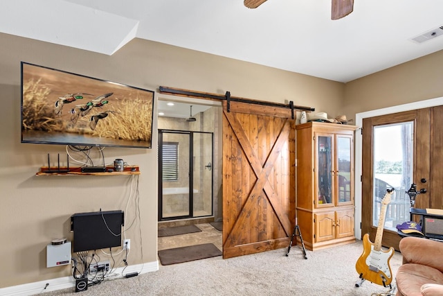 carpeted living room with a barn door and ceiling fan