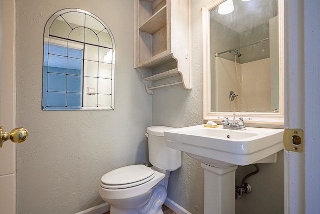8228A Ponderosa Dr, Silsbee, TX 77656 - bathroom featuring toilet, a textured wall, a shower, and baseboards