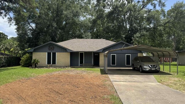8228A Ponderosa Dr, Silsbee, TX 77656 - ranch-style home featuring concrete driveway, a front lawn, brick siding, and a detached carport