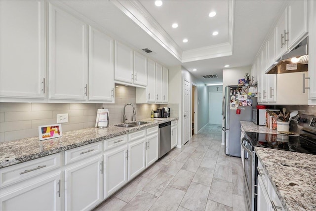 6650 Windwood Ln, Beaumont, TX 77706 - kitchen featuring appliances with stainless steel finishes, under cabinet range hood, a sink, a tray ceiling, and white cabinets