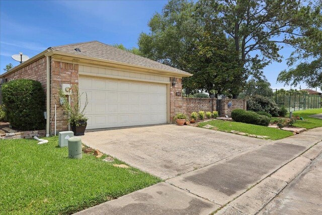 6650 Windwood Ln, Beaumont, TX 77706 - view of side of property with driveway, brick siding, an attached garage, and roof with shingles