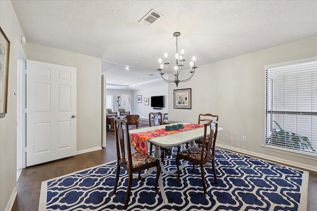 6650 Windwood Ln, Beaumont, TX 77706 - dining room featuring wood-type flooring, a chandelier, baseboards, and a textured ceiling