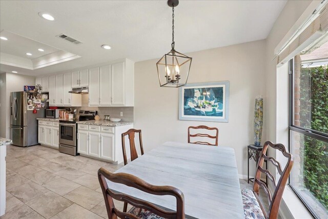 6650 Windwood Ln, Beaumont, TX 77706 - dining space with a chandelier, recessed lighting, and a tray ceiling