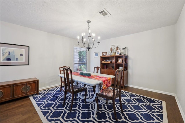 6650 Windwood Ln, Beaumont, TX 77706 - dining room with a chandelier, dark wood-style flooring, a textured ceiling, and baseboards