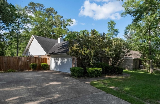 269 E Chance Rd, Lumberton, TX 77657 - view of property exterior featuring brick siding, driveway, a chimney, and a garage