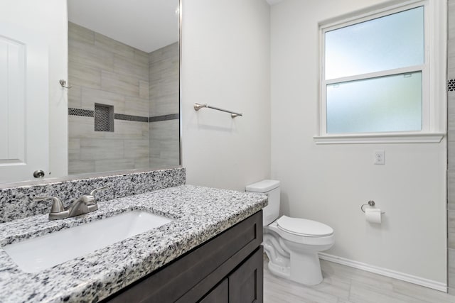 bathroom featuring walk in shower, vanity, and toilet